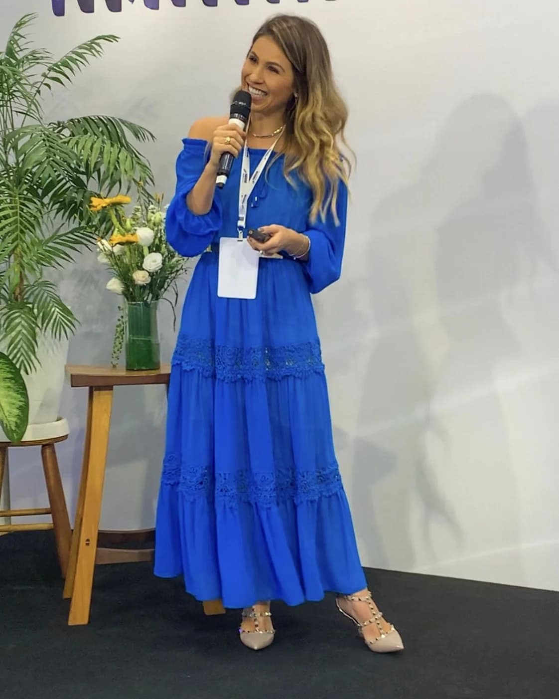 Mariana Della Torre, nutricionista, palestrando com microfone em evento, São Paulo